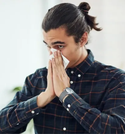 Man with a blocked nose using a tissue